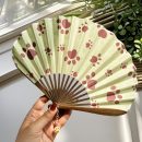 Folding fan with dog paw print pattern