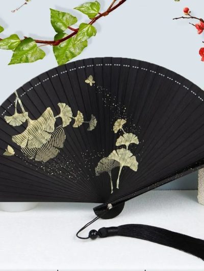 Folding fan with silver maple leaf and gold moon pattern