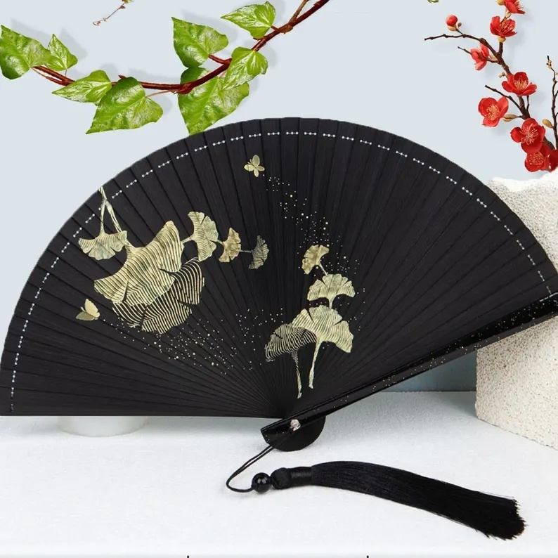 Folding fan with silver maple leaf and gold moon pattern
